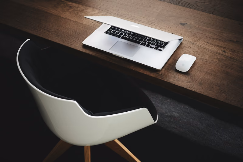 Aufgeräumter Schreibtisch mit Laptop – Sinnbild für einen schlanken Software-Stack von Finanzierungsvermittlern